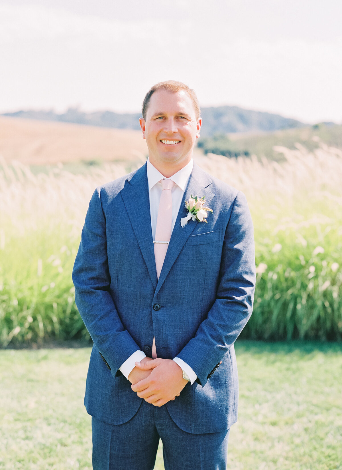 groom in blue suit smiling at the camera
