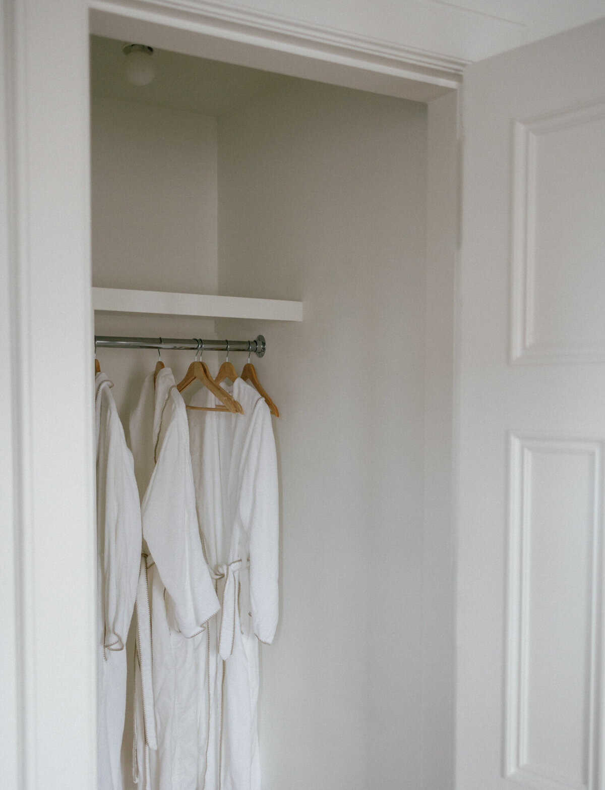 fluffy white bathrobes hang in clean warm white closet, ALEO Detroit bed & breakfast