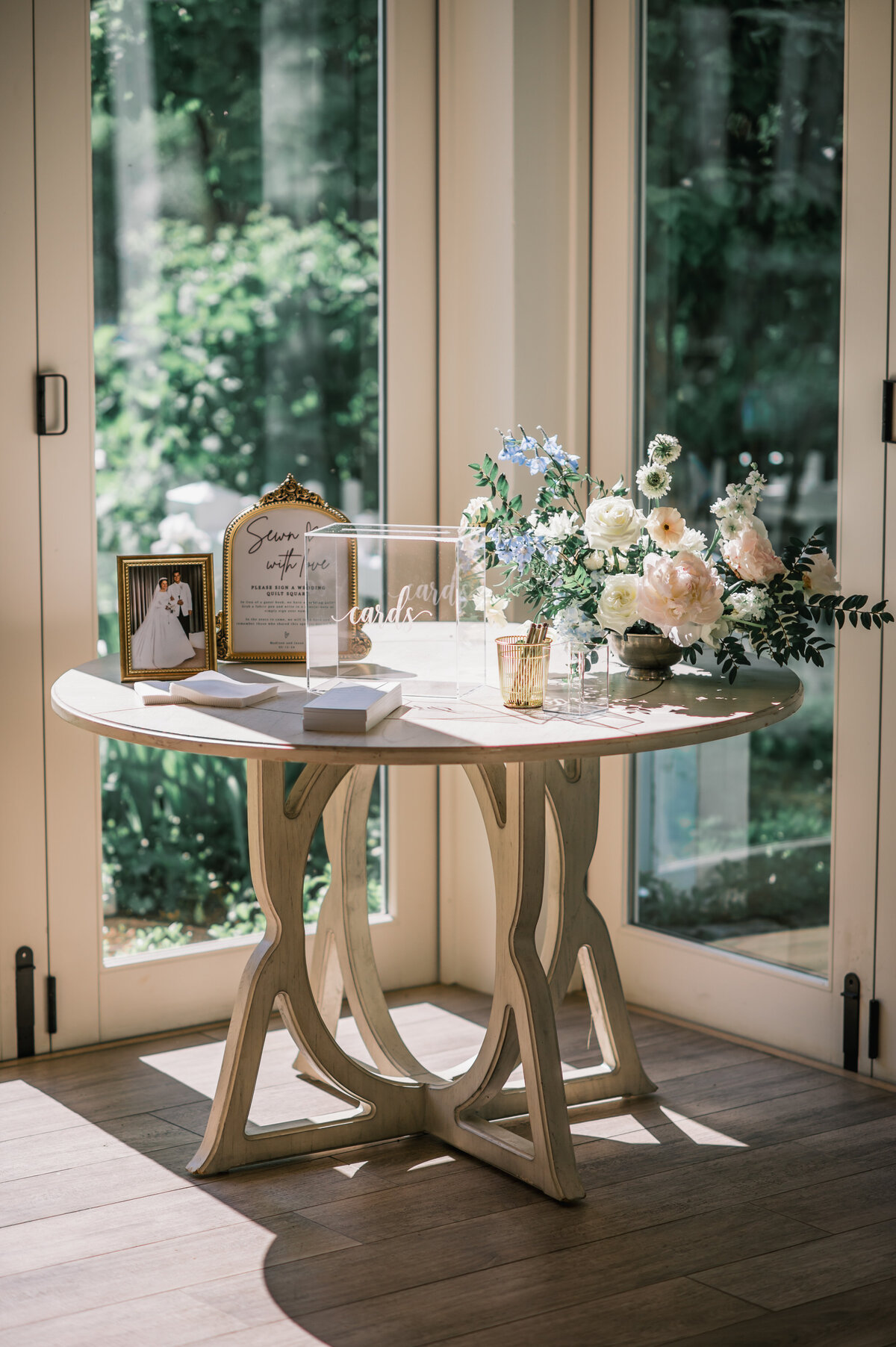 Wedding welcome and card table setup at Old Edwards Inn in Highlands, NC featuring acrylic card box, framed sign, and pastel floral arrangement.