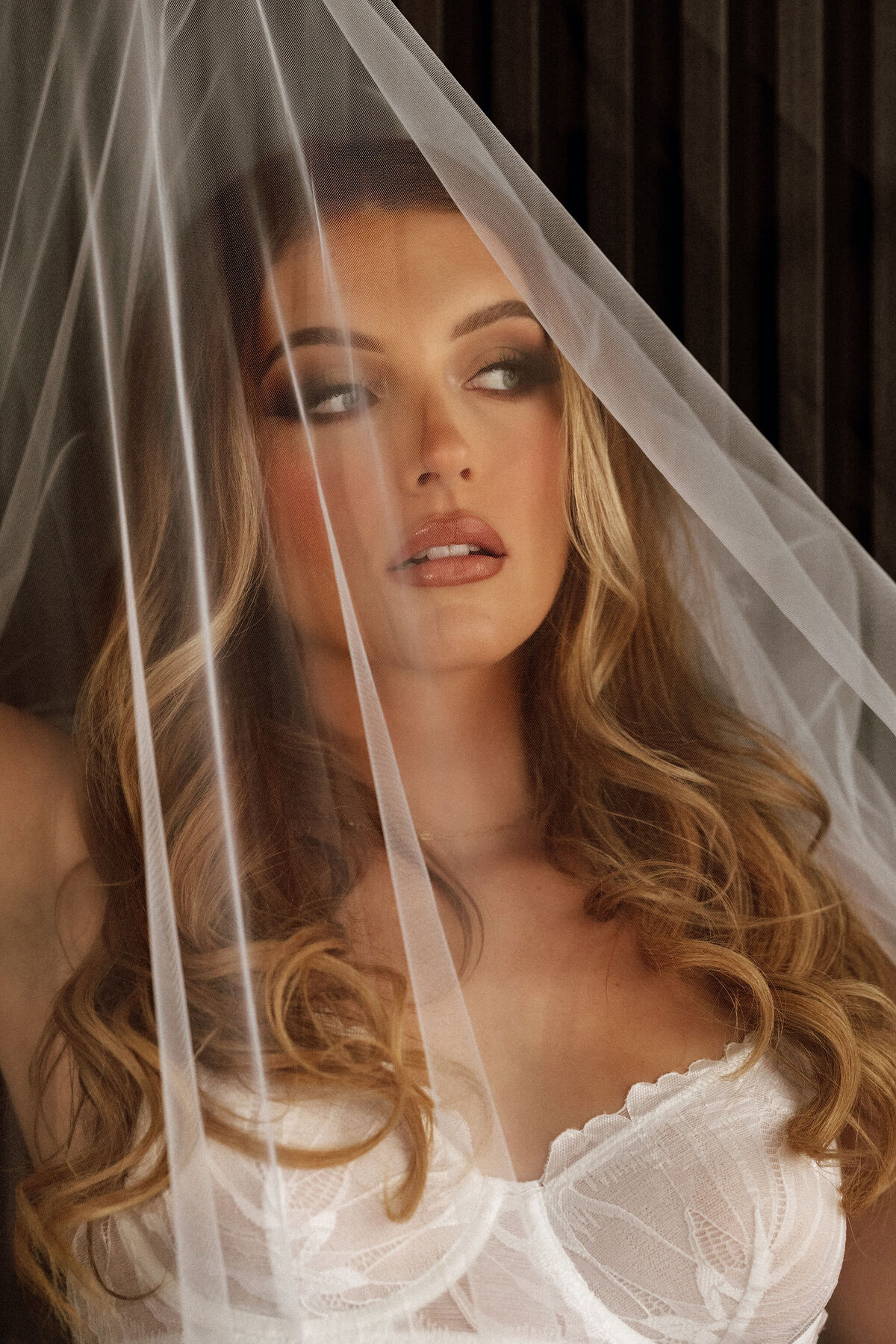 Close-up of woman’s face under bridal veil with soft glam makeup intimate boudoir portrait in Tampa, Florida.