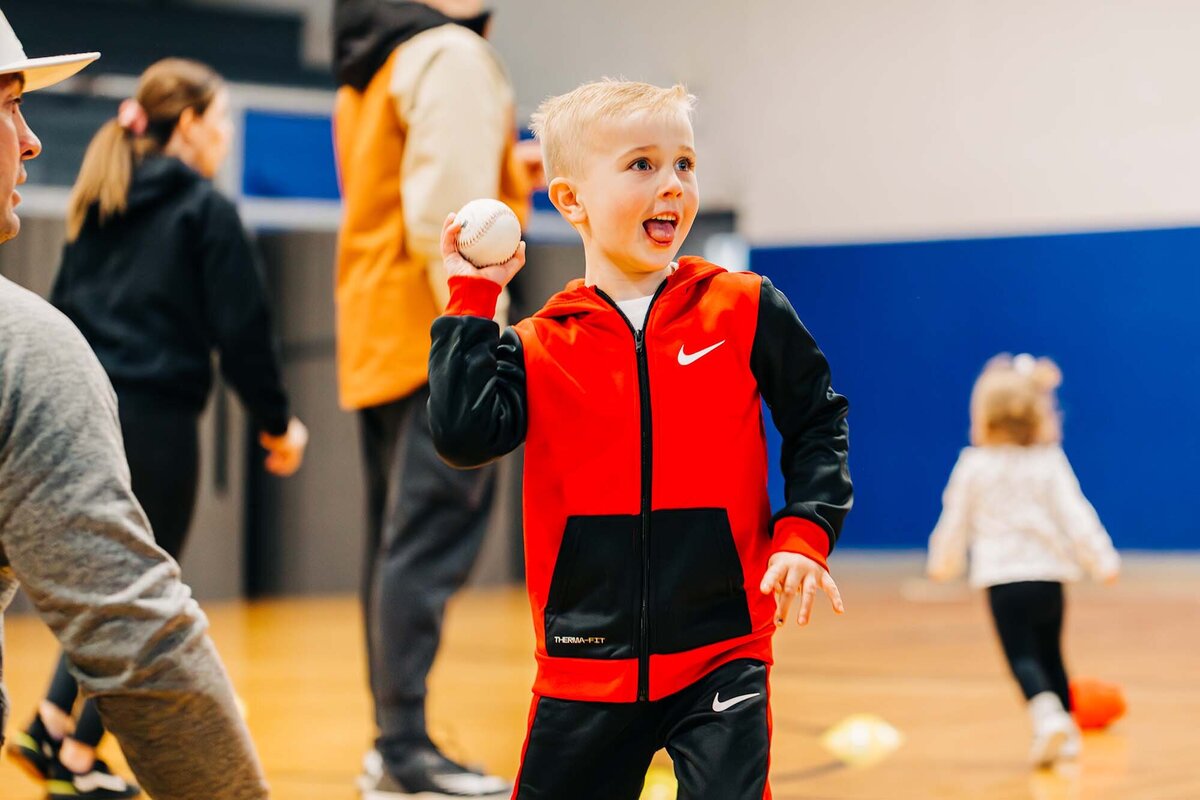 Little boy in red track suit at tee ball practice