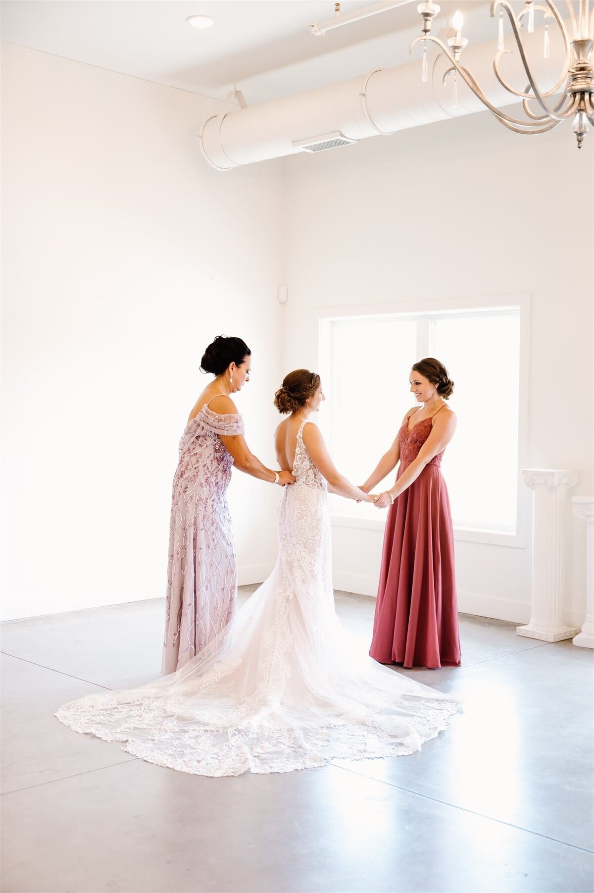 Mother and daughters getting ready during summer wedding