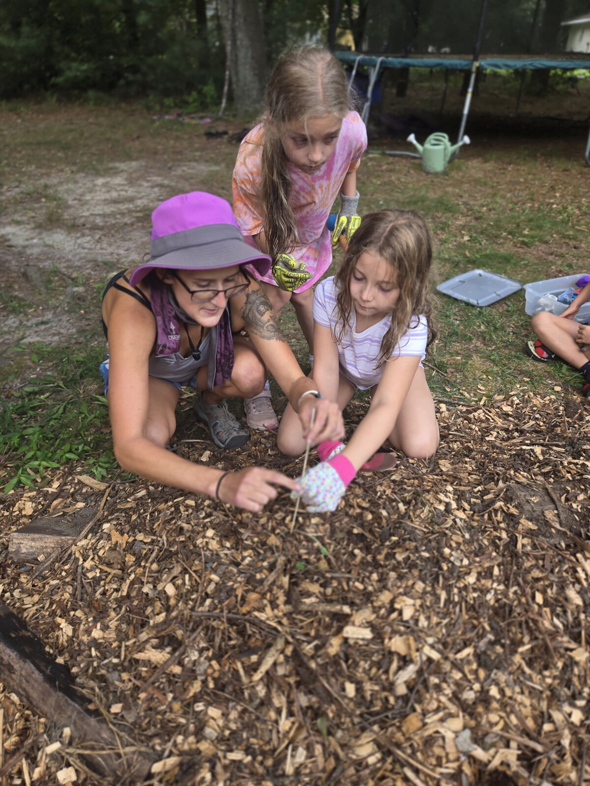 A ROOTS educator exploring the ground with young learners