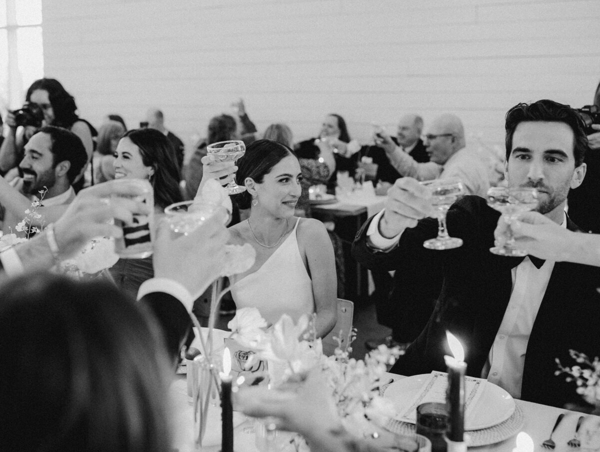 Bride and groom toasting at Wedding reception with yellow florals at Prospect House Austin