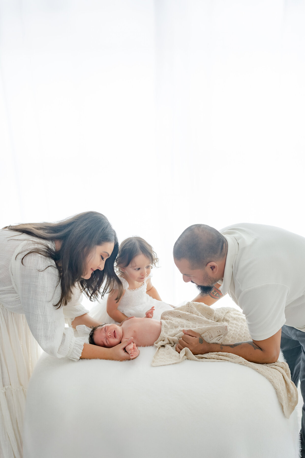 Family holding newborn during natural light Barrie newborn photography session 