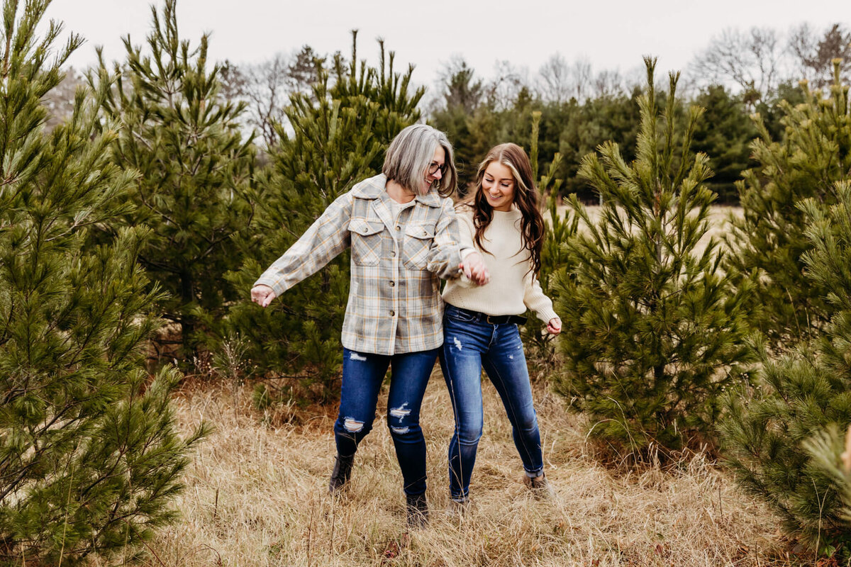 Mother and daughter dancing together in the pine trees at a tree farm near Oshkosh, WI.