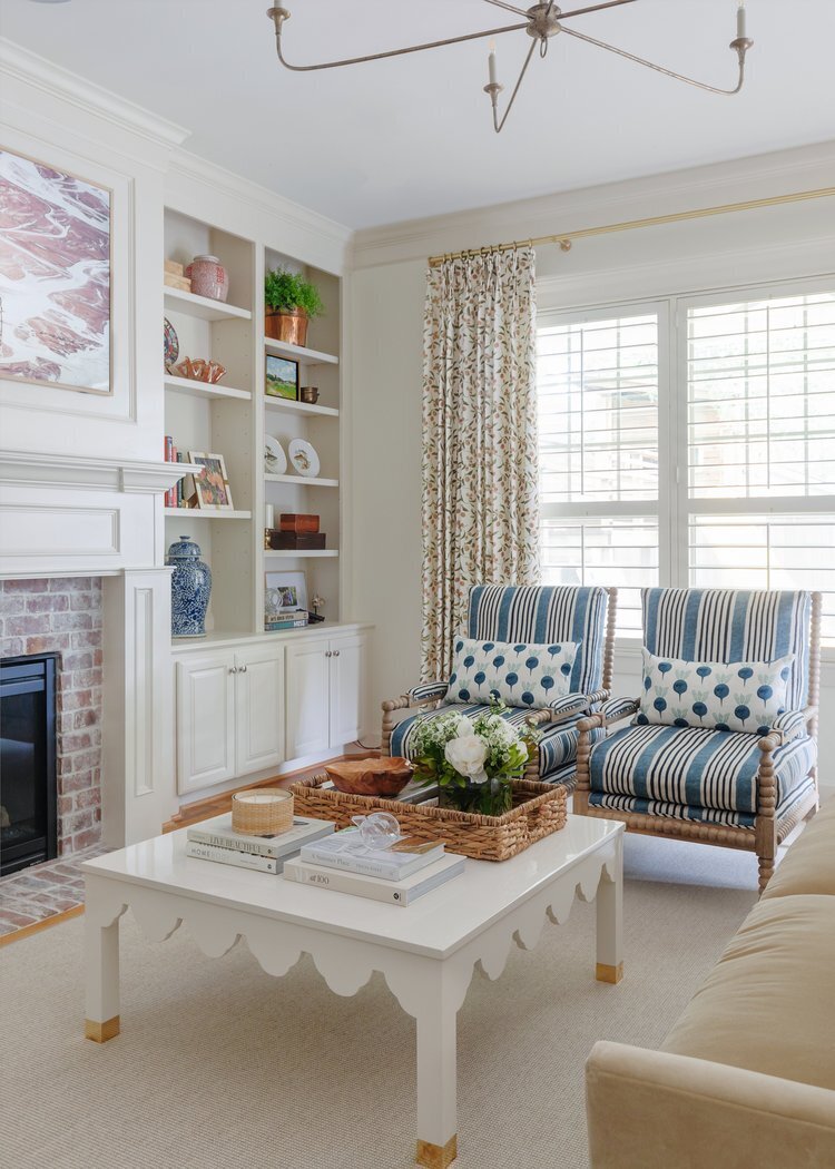 oyster creek studios oak forest remodel striped blue armchairs around a white coffee table in living room with shelving