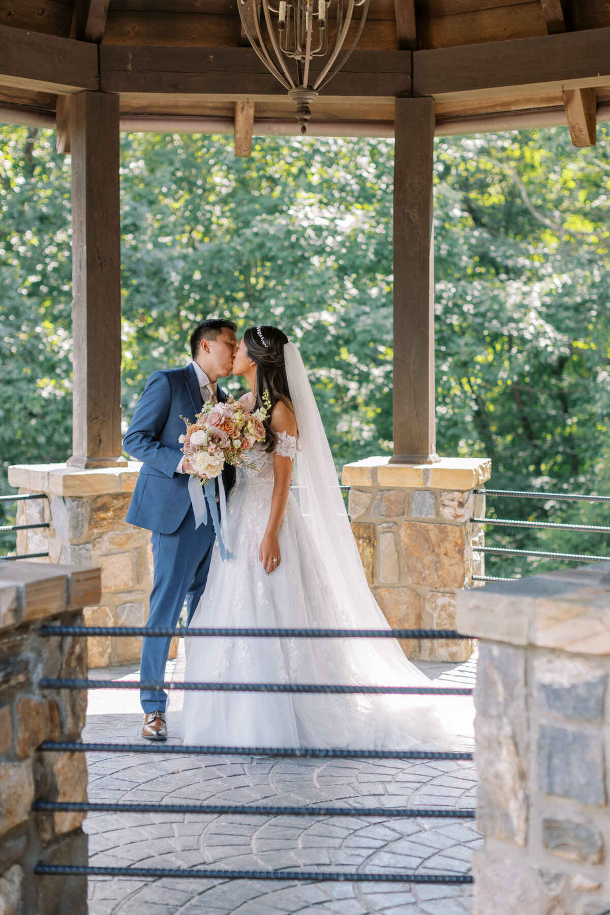 Bride and groom sharing a kiss during their first look in the covered overlook pavilion at Castle Ladyhawke.