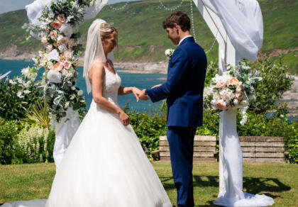 A bride and groom standing under a wedding arch