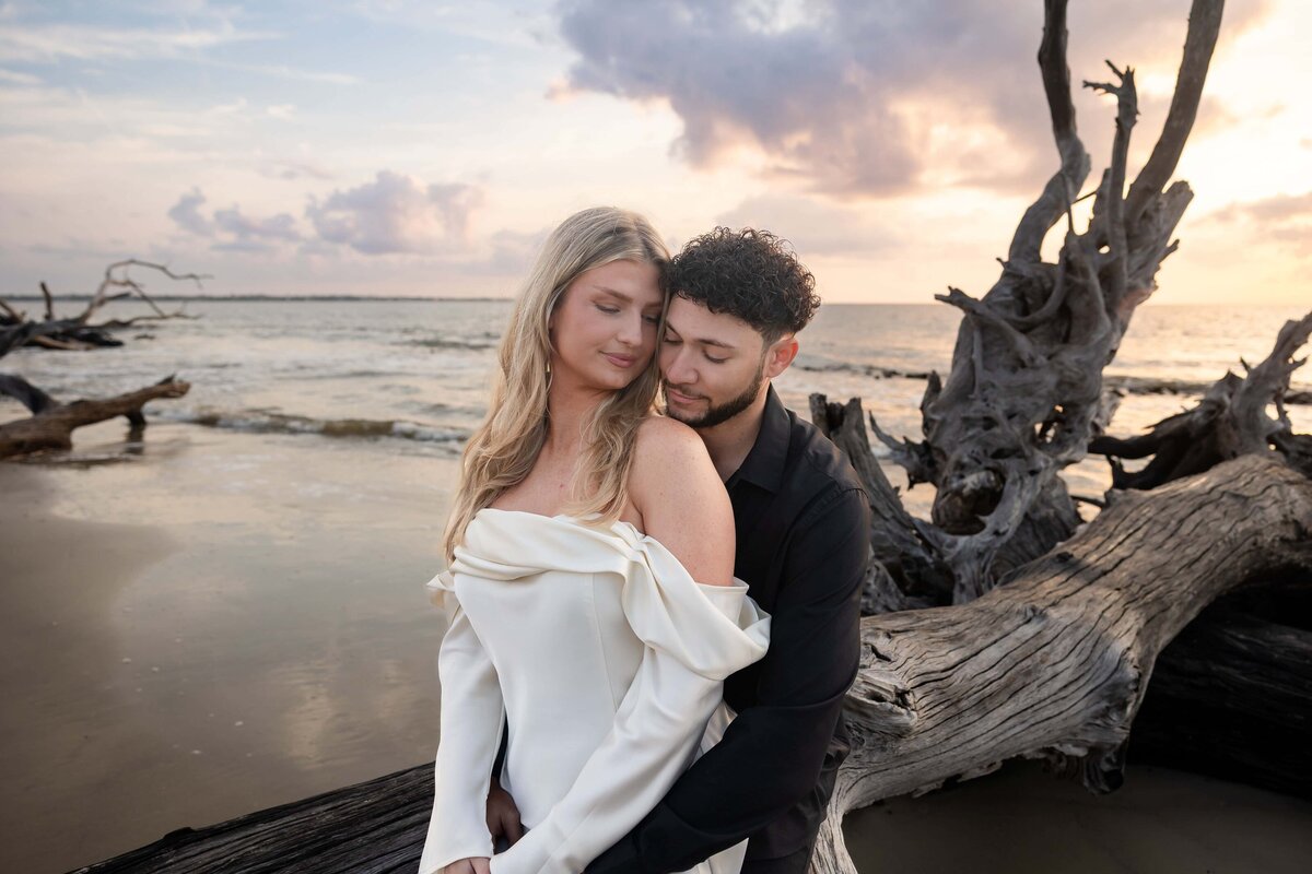 Bride in white silk dress embracing groom in black shirt – St. Augustine engagement photo