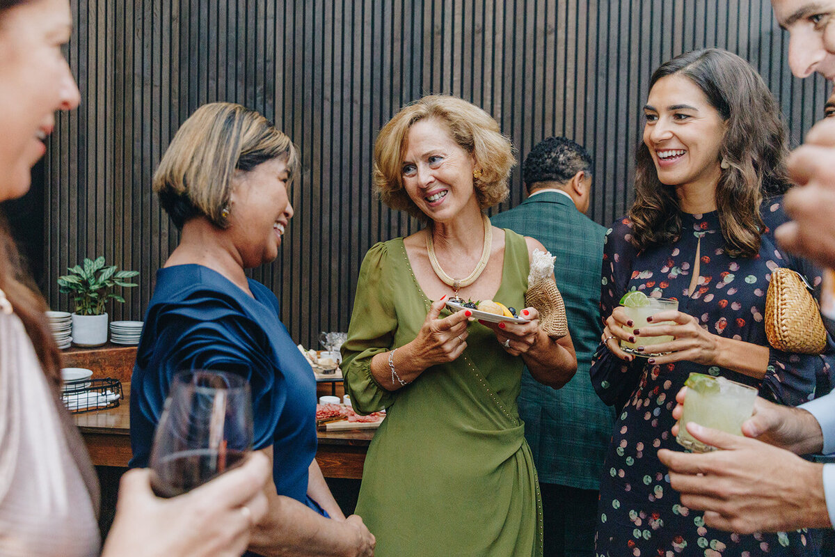 guests at cocktail hour. lady in a green dress