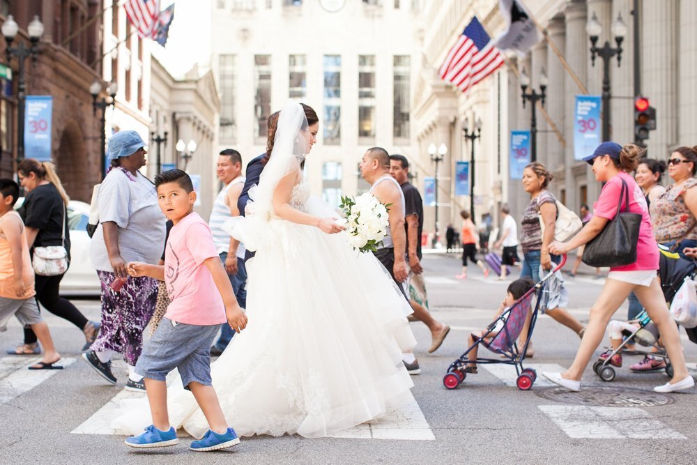 Bridal party walks with bystanders on Lasalle street in Chicago 