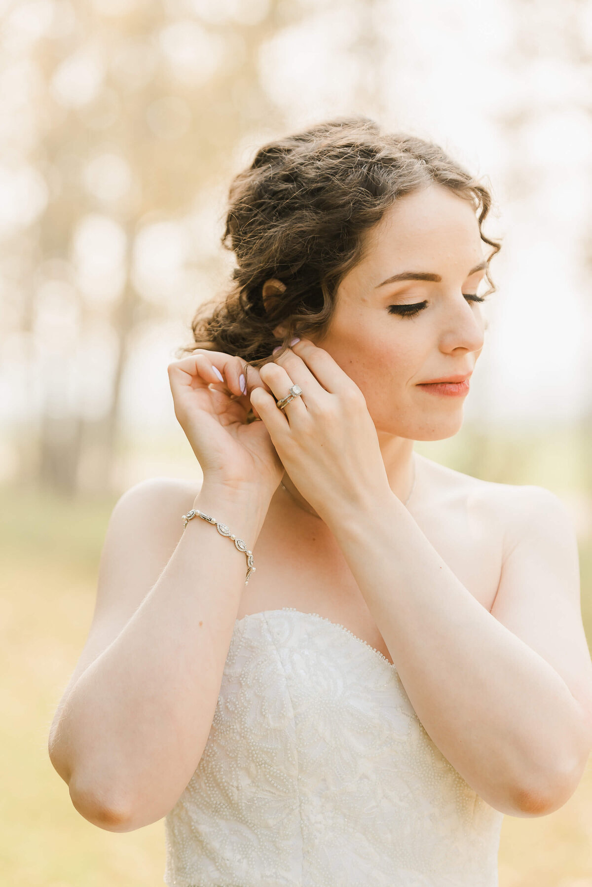 A Fort Saskatchewan bride fixing her earrings for an editorial wedding vibe