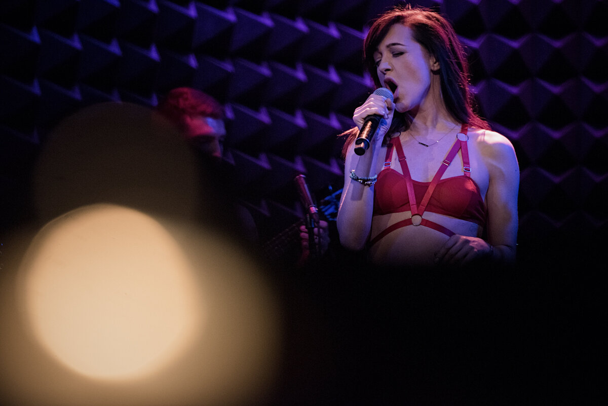 A person singing while standing on a stage