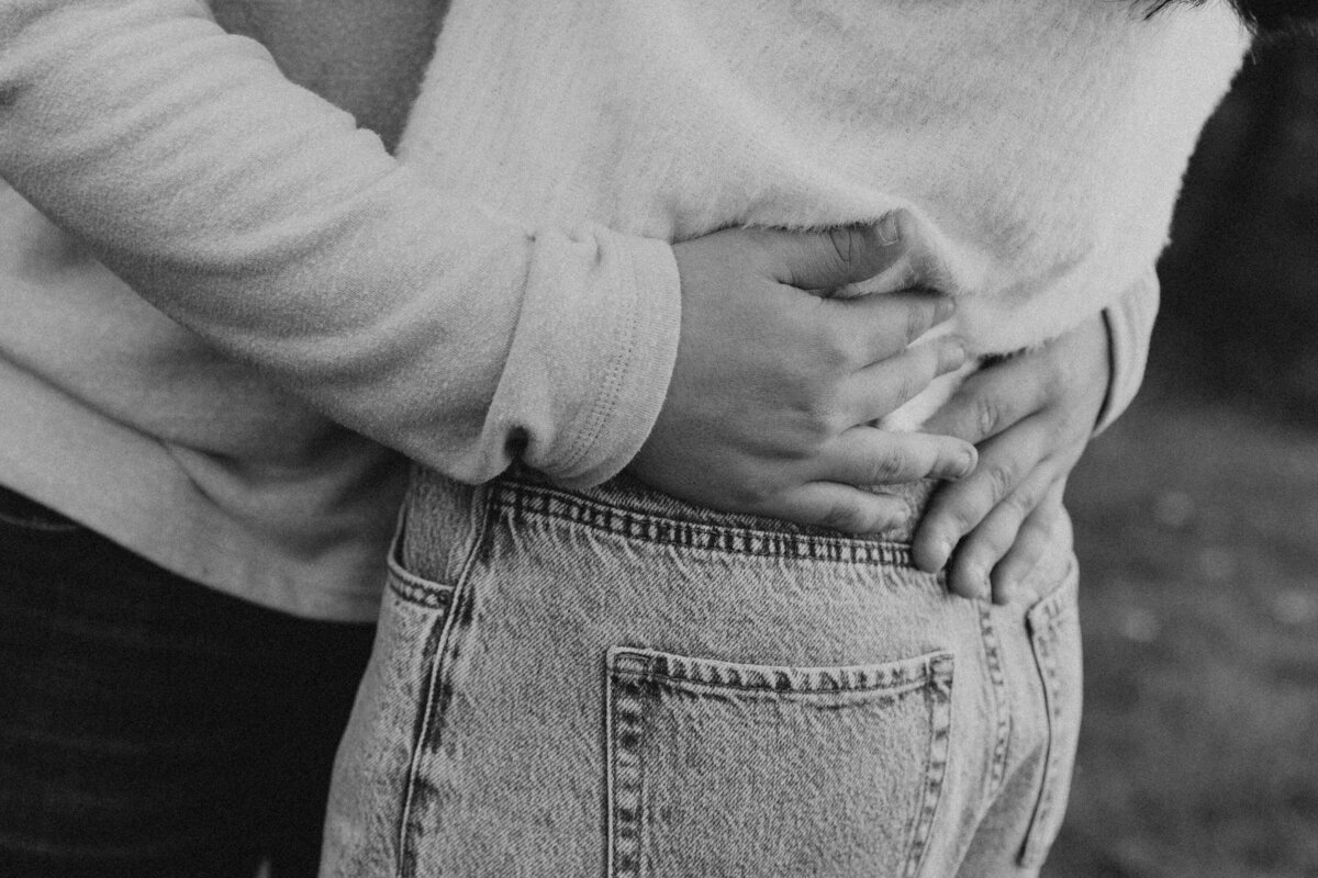 Close-up of couple’s embrace in jeans and sweaters, emotional and artistic Midwest engagement photography for modern, sentimental couples