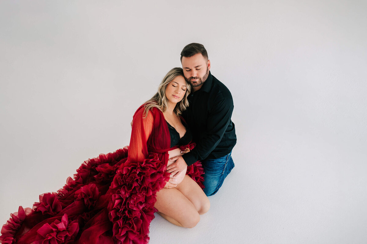 Joplin MO maternity photographer Jessica Kennedy of The XO Photography captures pregnant couple closing eyes kneeling on floor