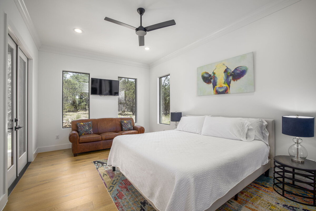 guest bedroom with wood floors and picture windows