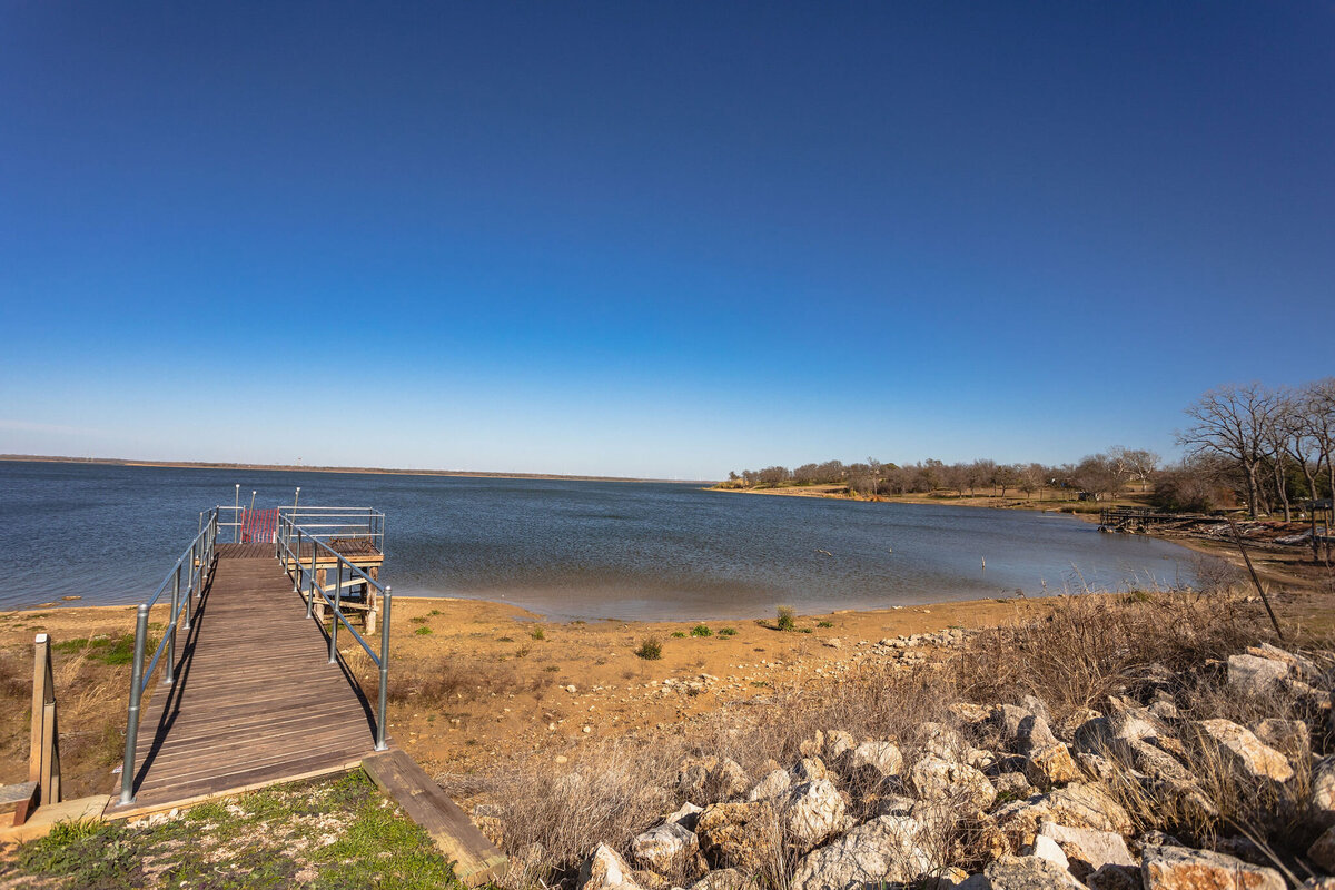 Access to fishing dock and boat loading area at this 2-bedroom, 2-bathroom lakeside vacation rental home for 6 guests on Tradinghouse Lake with privacy access to a fishing dock and boat launch pad, ping pong table, gazebo, free wifi and free parking in Waco, TX.