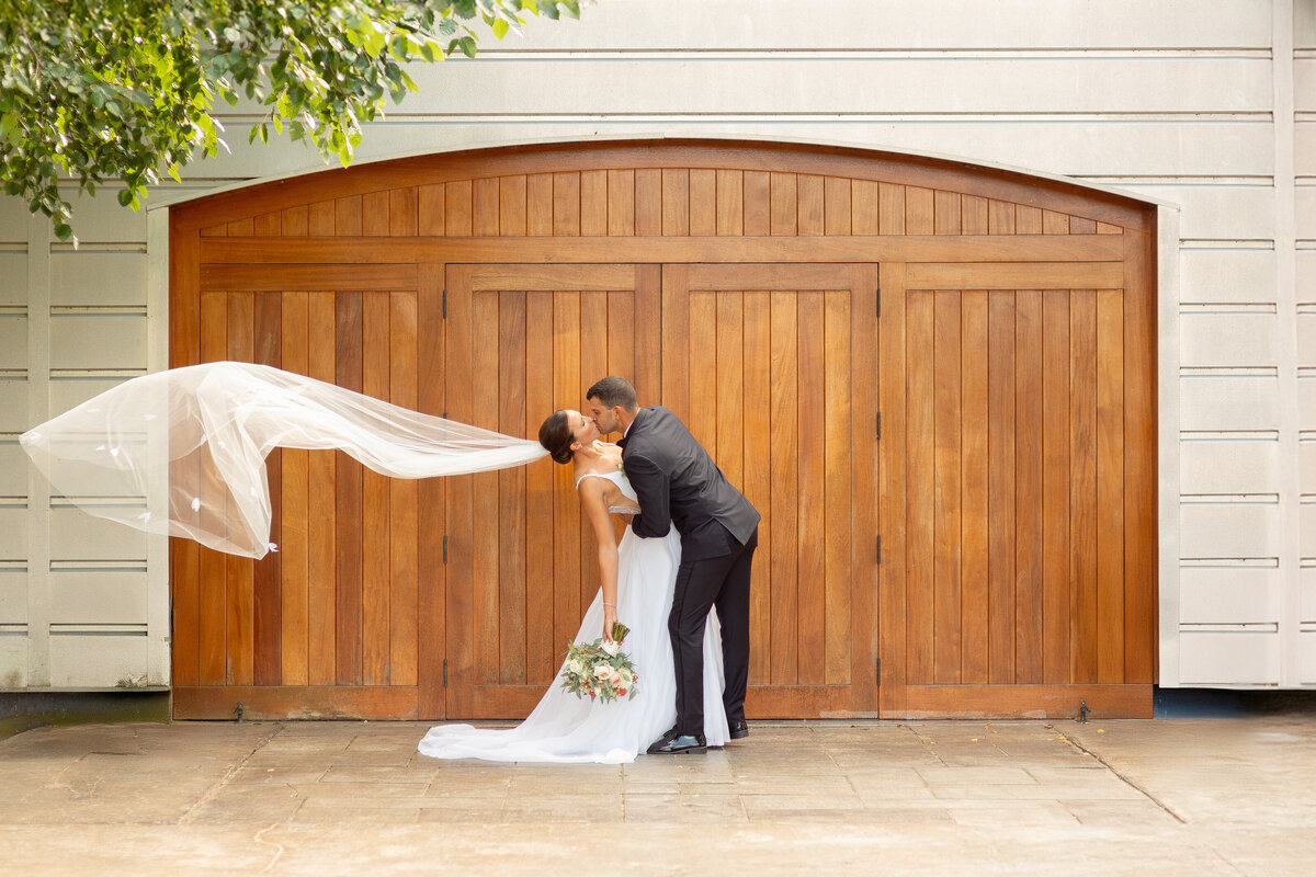 Newlyweds hold hands and smile at each other as they walk.