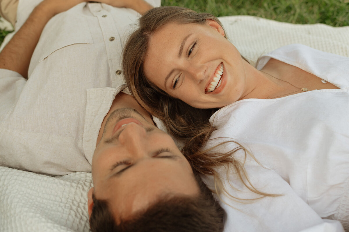 Couple enjoying a cozy picnic with wine and charcuterie at a tropical vineyard

