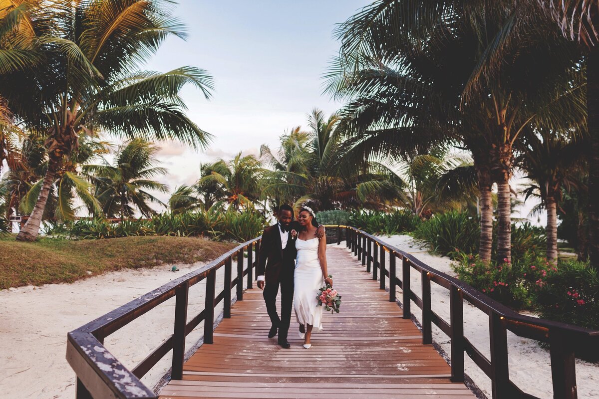 Bride and groom on path at wedding in Cancun