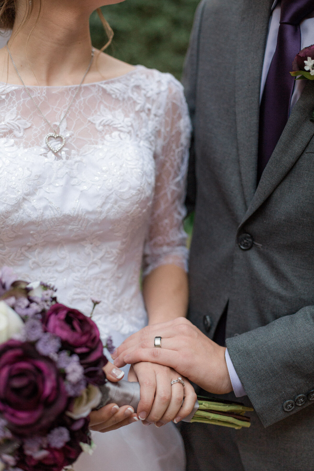 A close up image featuring the new couples wedding bands and the brides bouquet
