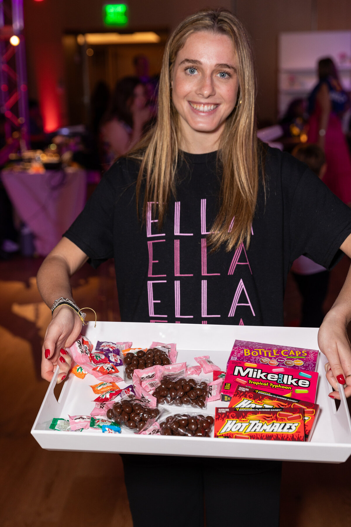 A girl holding up a tray of candy