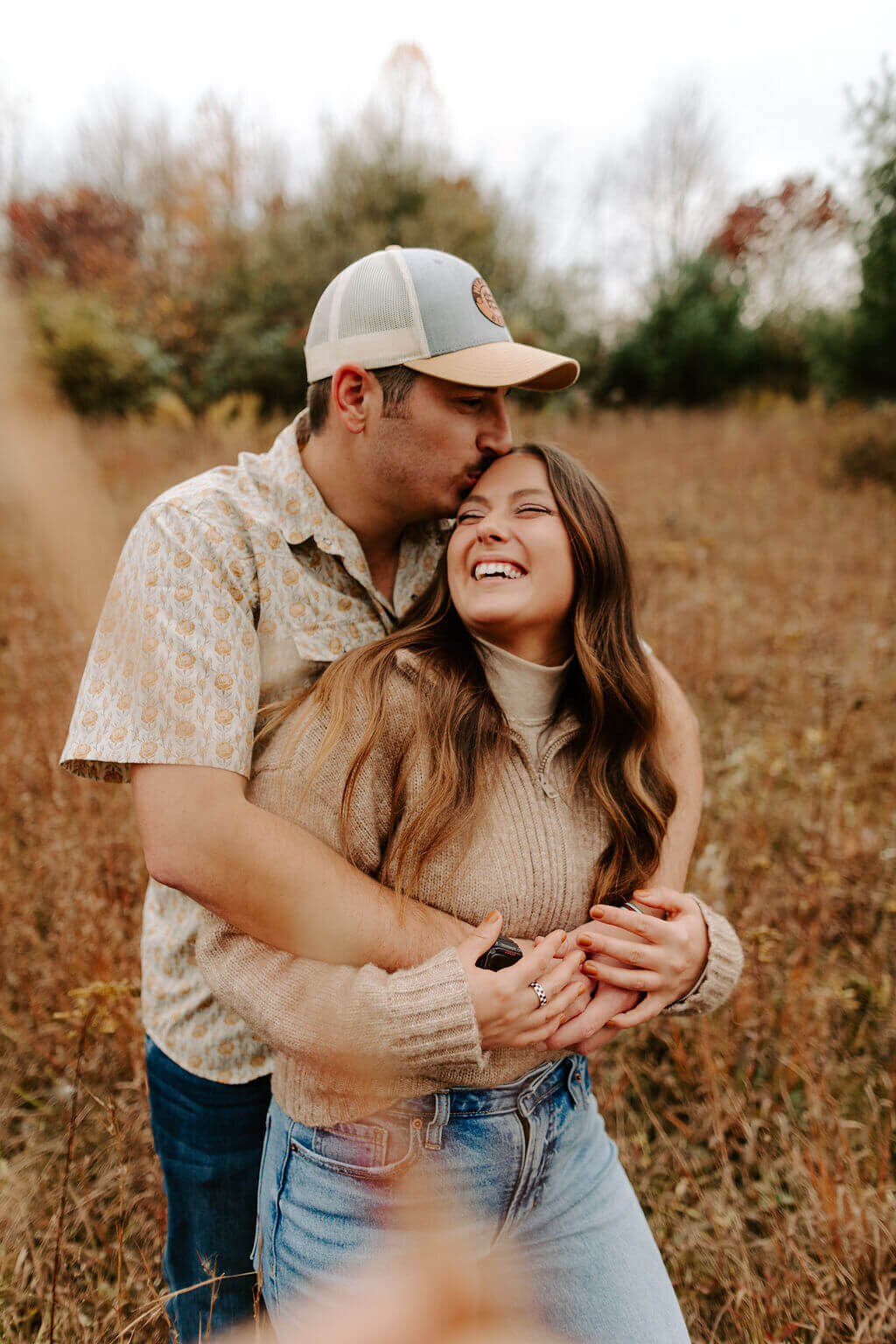 couple posing in field in fall