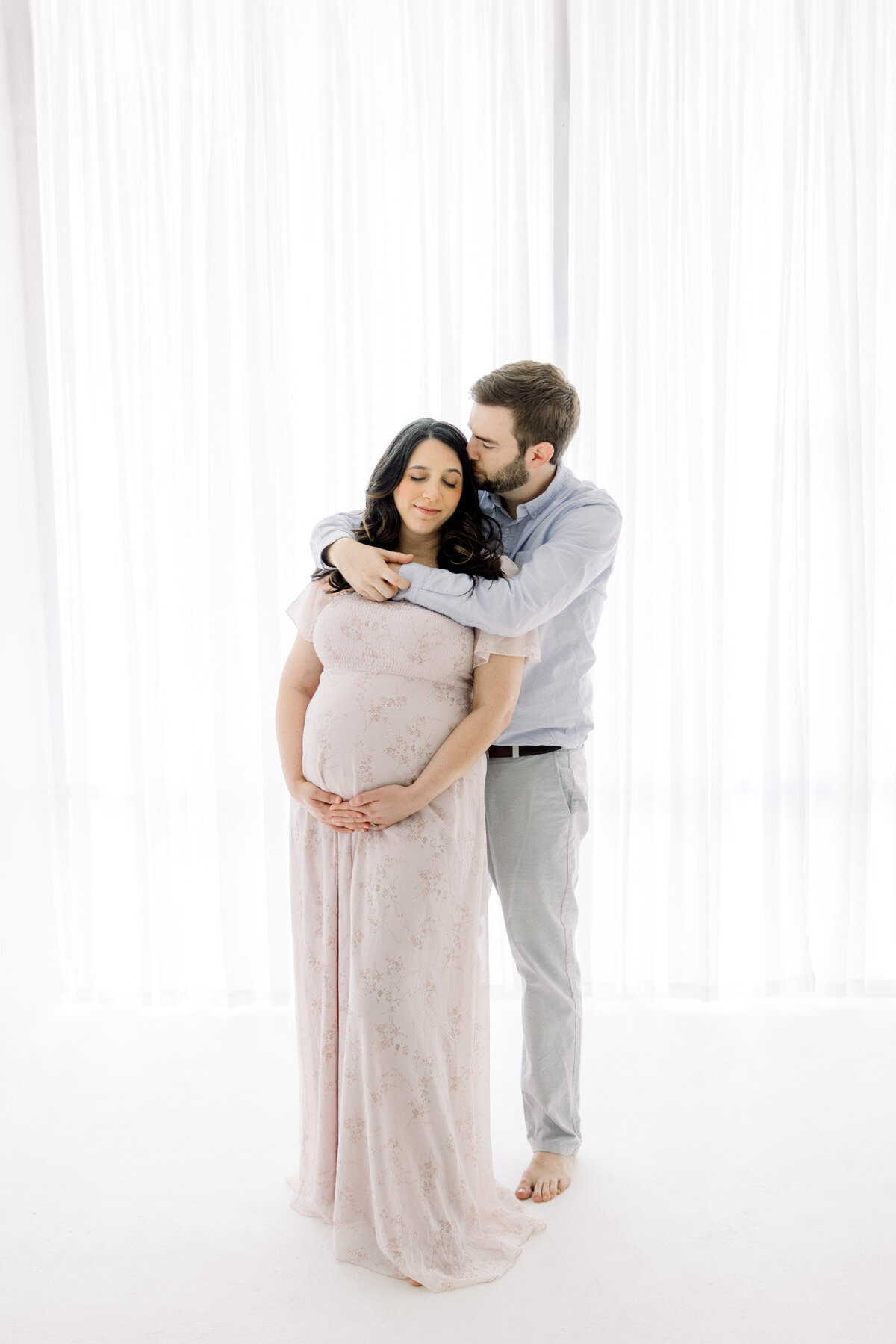 Pregnant couple kissing wife's head for Tampa maternity photographer Tina Marie Studio.