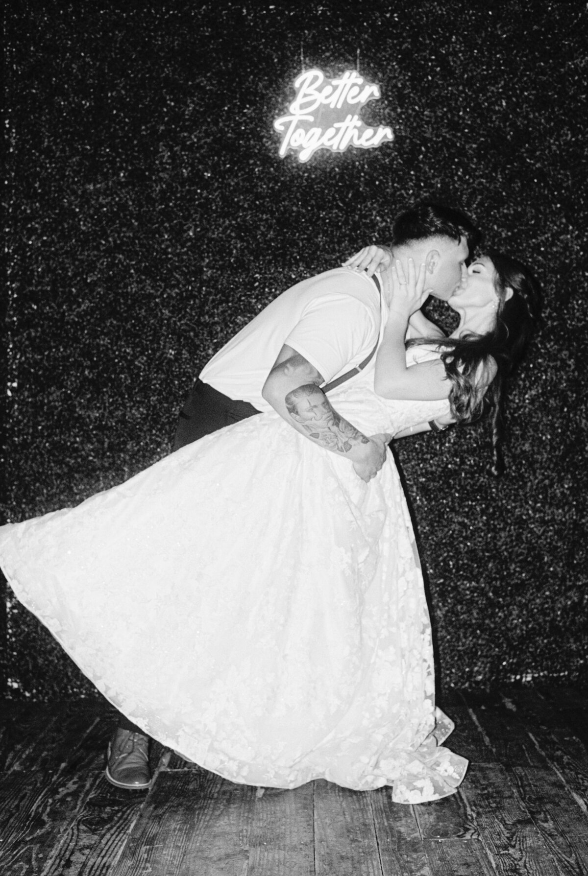 A timeless black-and-white portrait of the bride and groom celebrating at their reception, elegantly captured on film by Morgan Alysse, Louisiana film photographer.