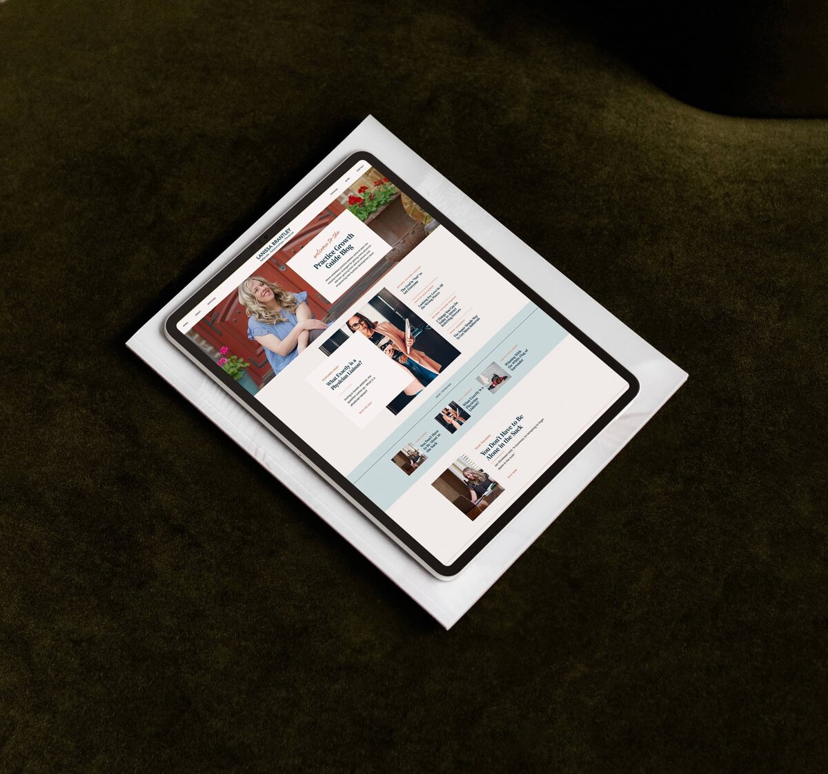 A tablet displaying a wedding planning website, designed using a Showit template customization for personal brands, showcases sections like photos of couples, articles, and event details. It lies on a white paper atop a dark fabric surface.