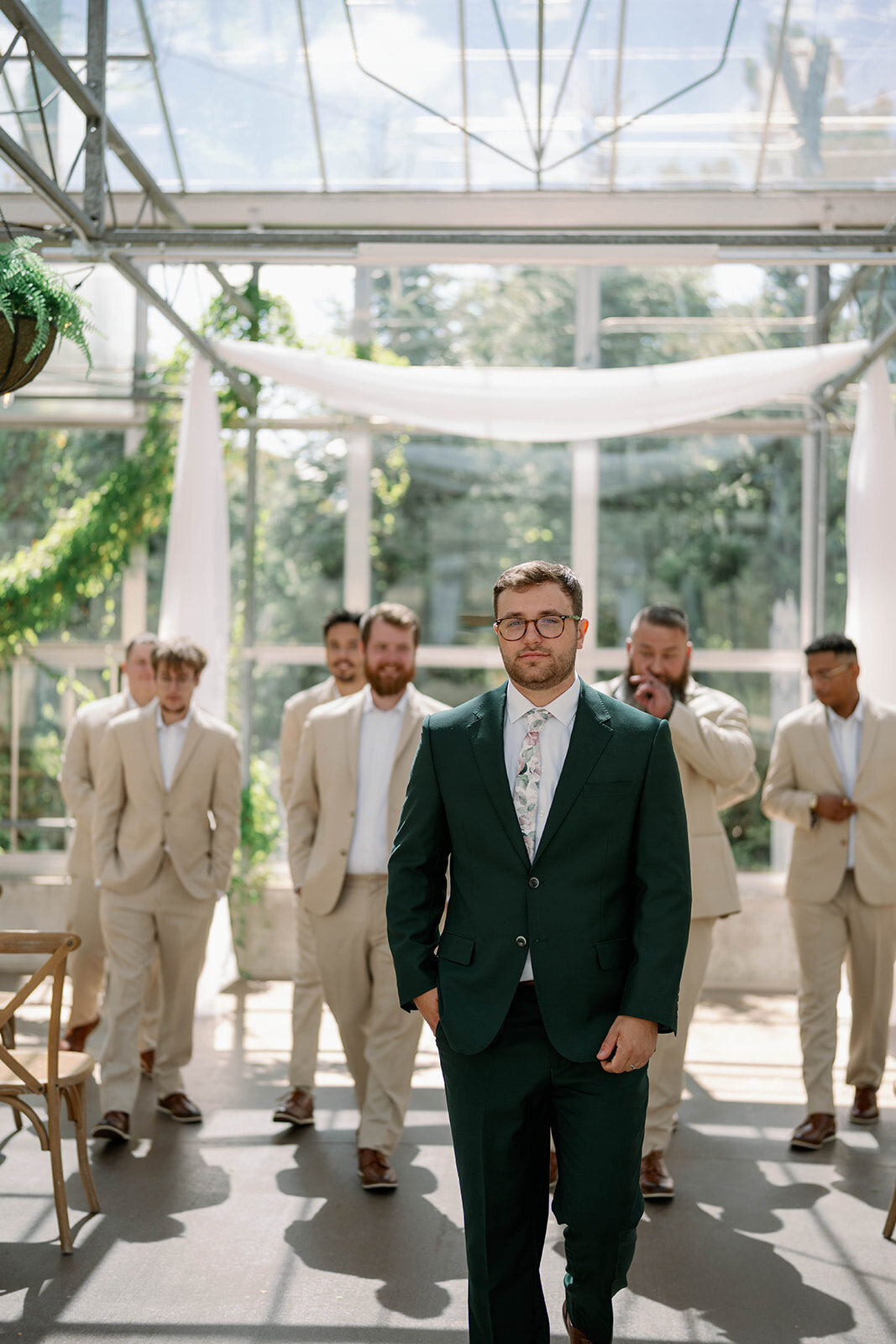 Candid photo of the groomsmen walking with the groom leading in front during Ivy House portraits.