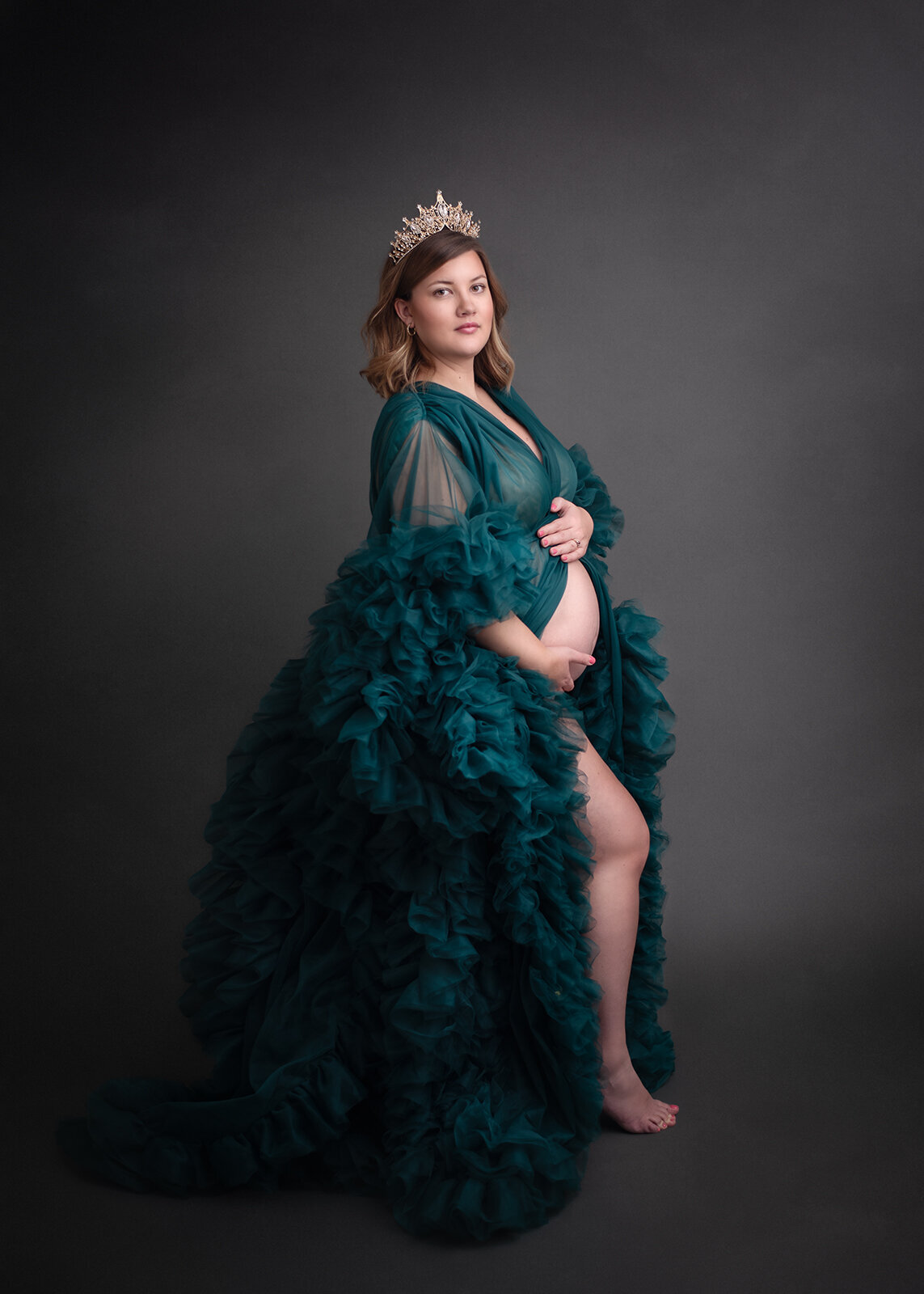 photo by st. louis maternity photographer of pregnant mom holding belly in tulle gown and tiara