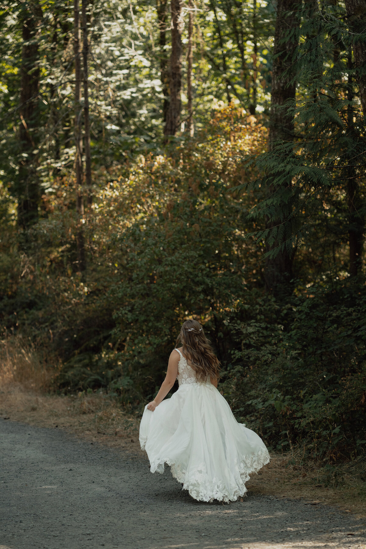 Bride running in the trails at Bowen Park in Nanaimo during her wedding portraits by Latitude 49 Photography