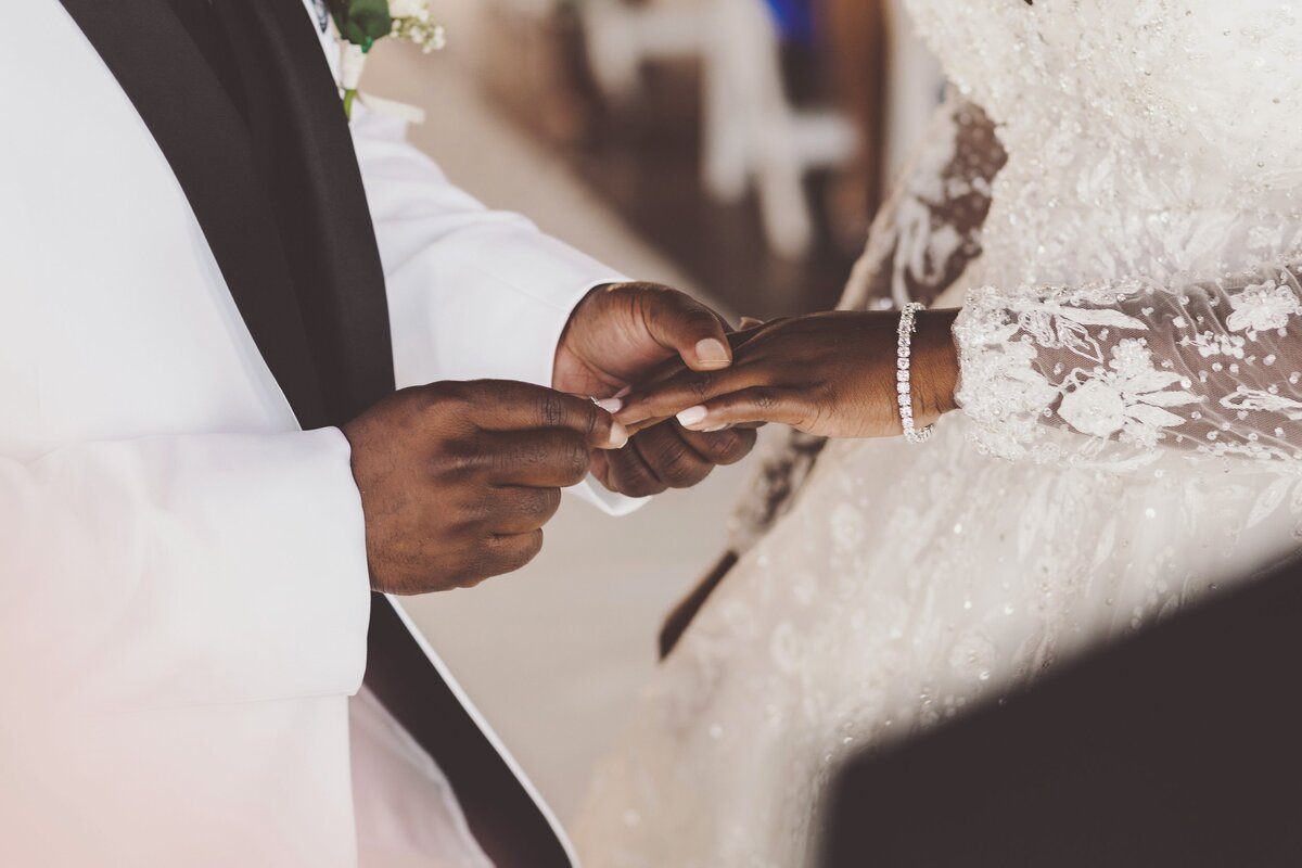 Groom putting on ring at wedding ceremony in Cancun