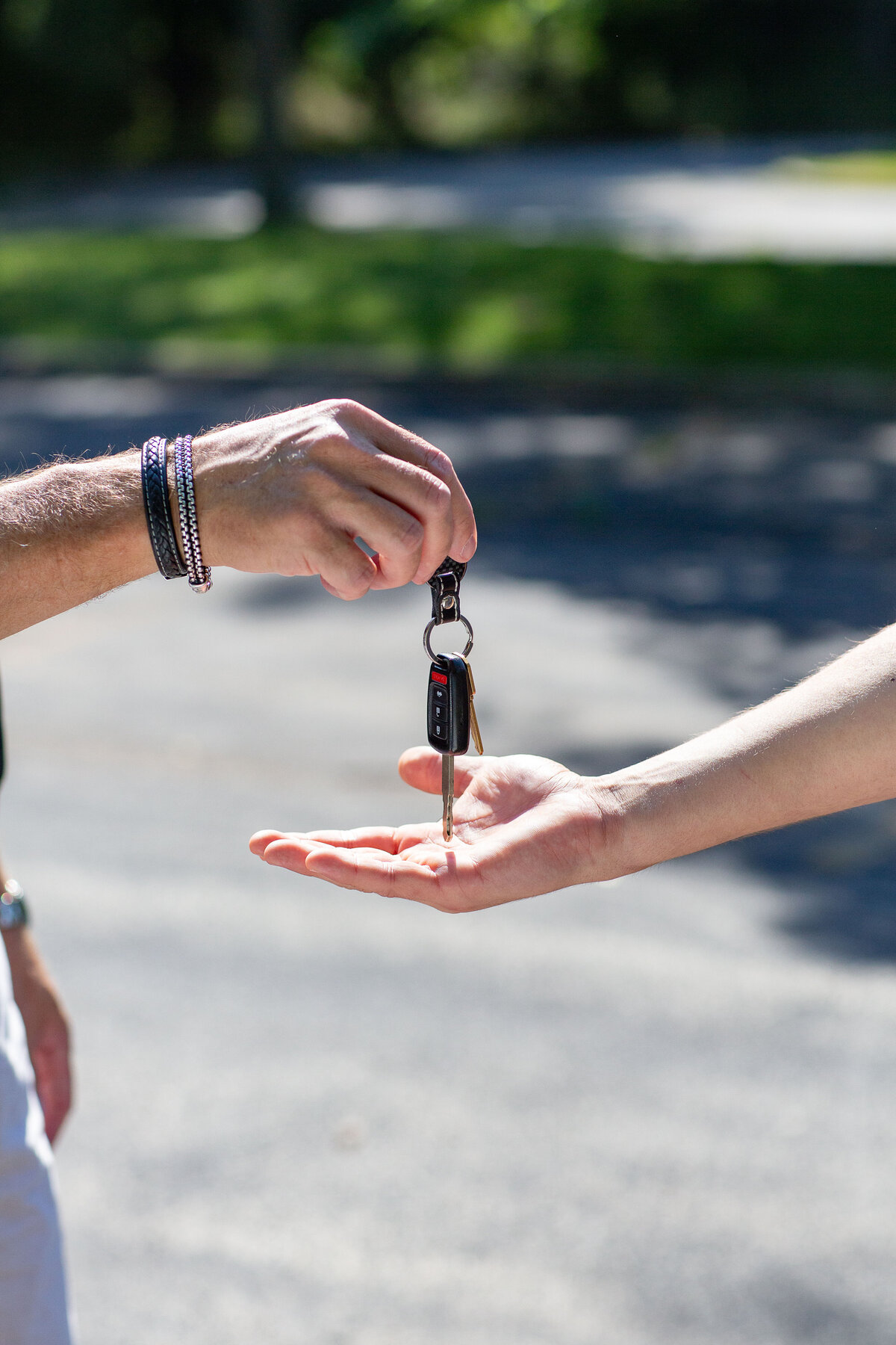 Hand giving keys to another hand