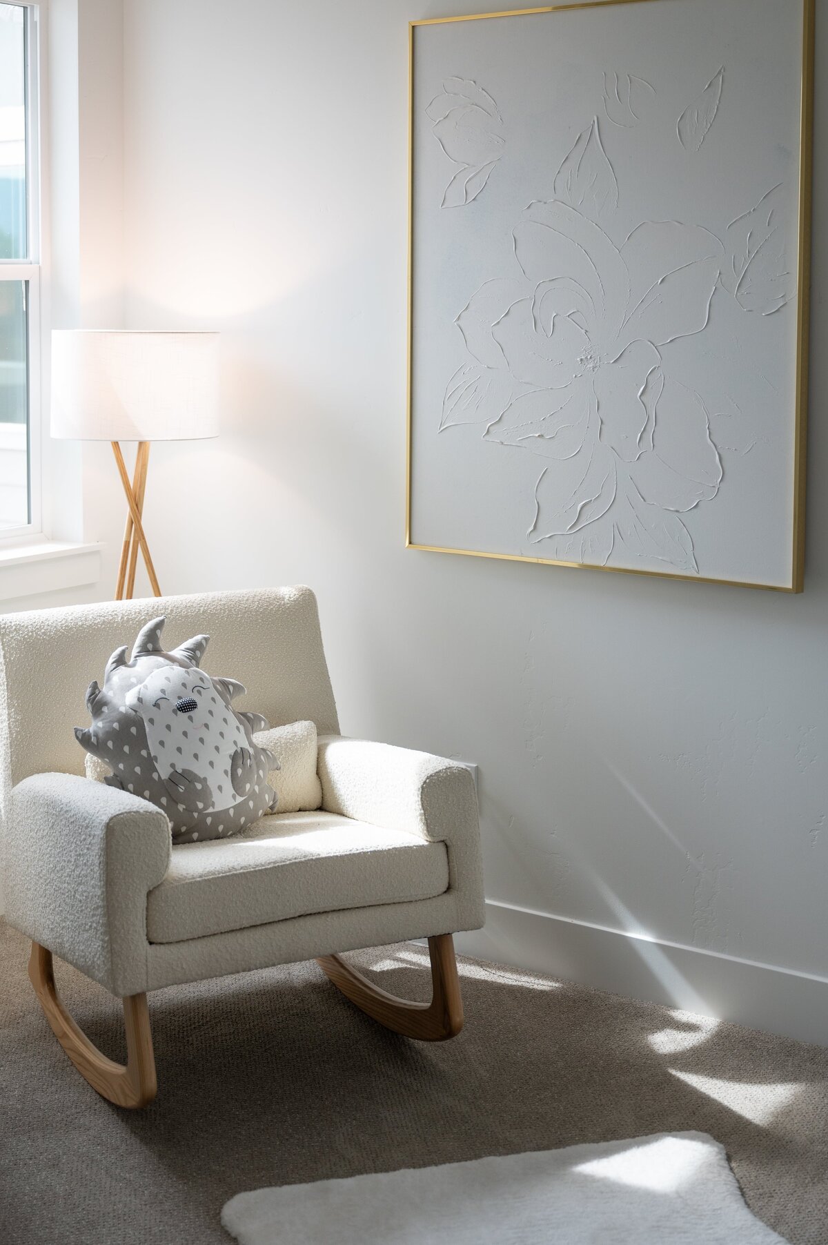 Nursery interior design with white rocking chair, crib, and artwork
