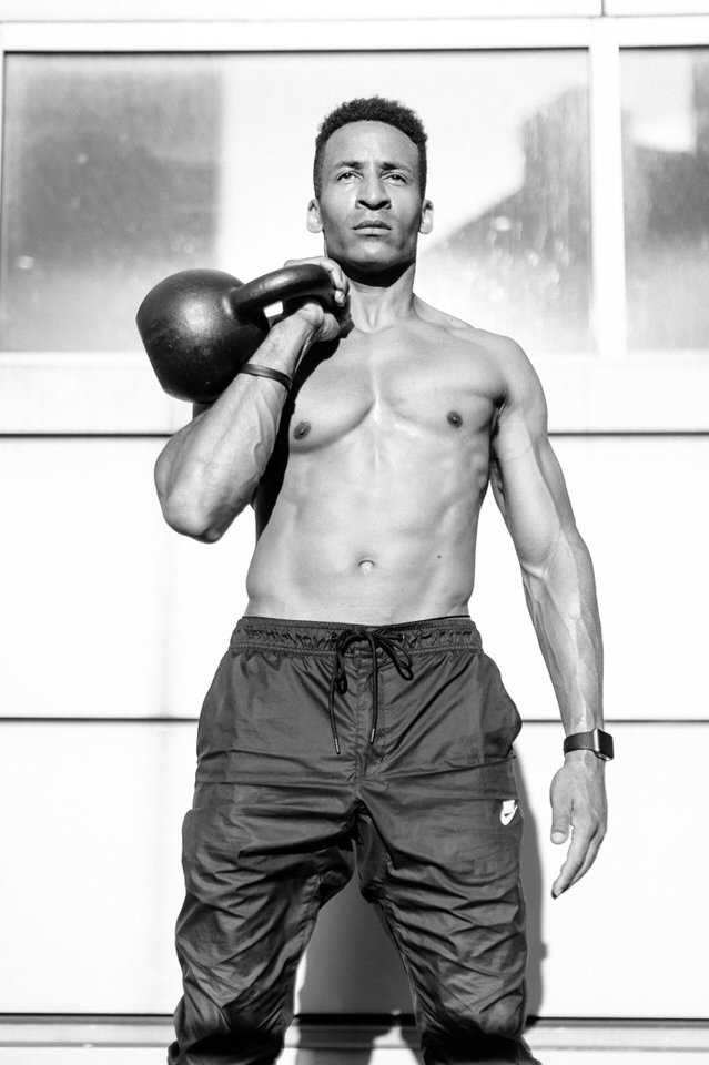 man holding a kettlebell for nyc photoshoot