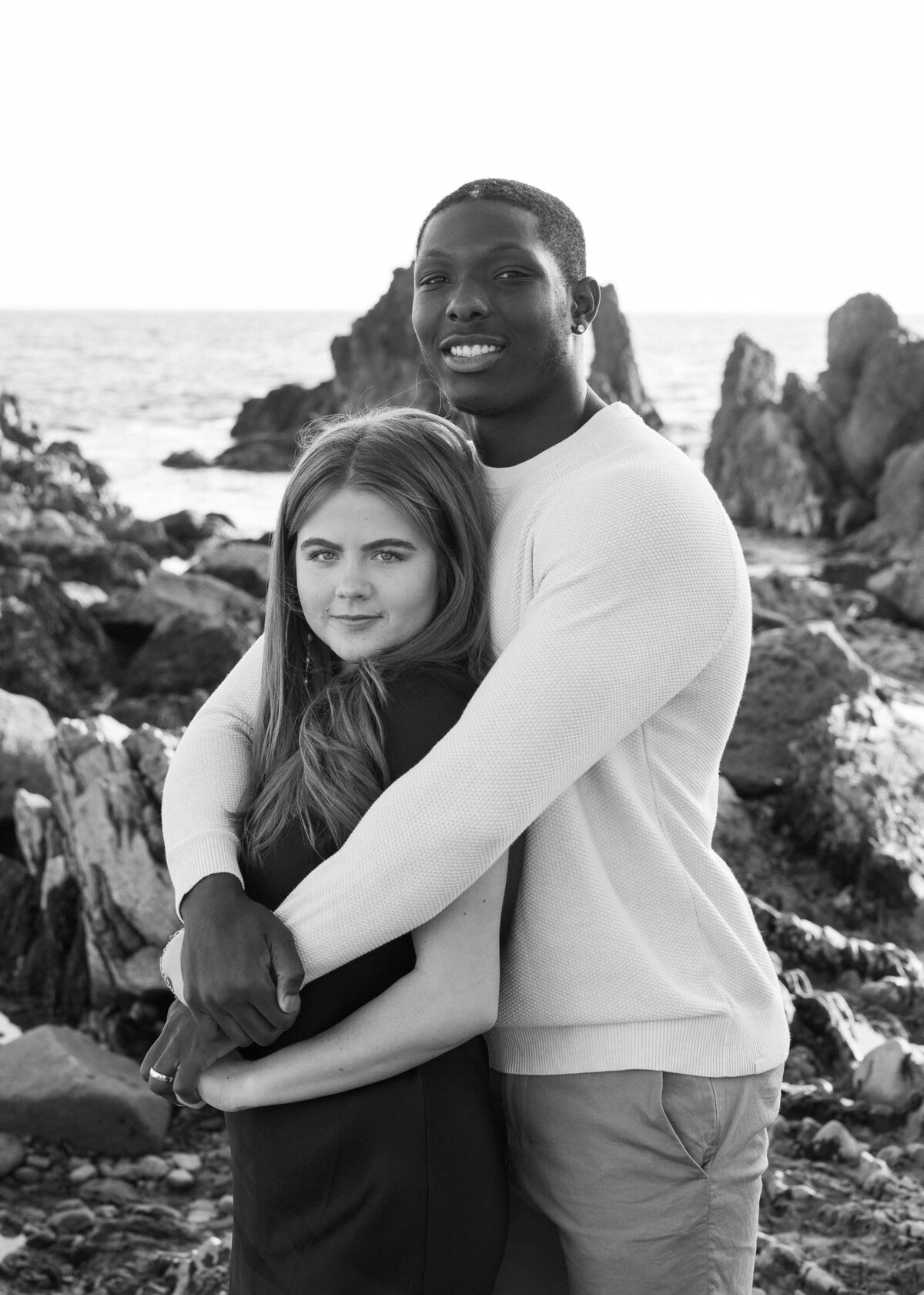 black and white photo of a couple smiling on the beach