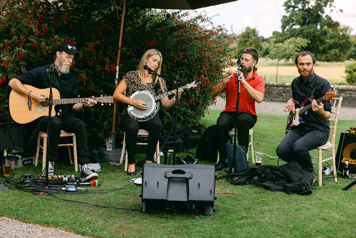 A wedding day photo of a traditional Irish music band playing during cocktail hour at a awedding at Luttrellstown Castle
