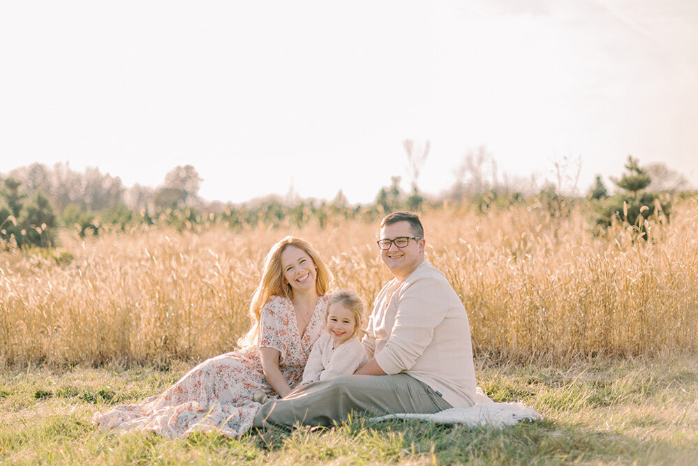 Family of three on a blanket in a field