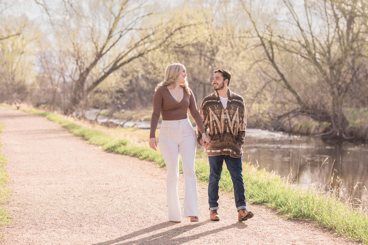 A couple converse as they walk beside the water at Walden Pond in Boulder
