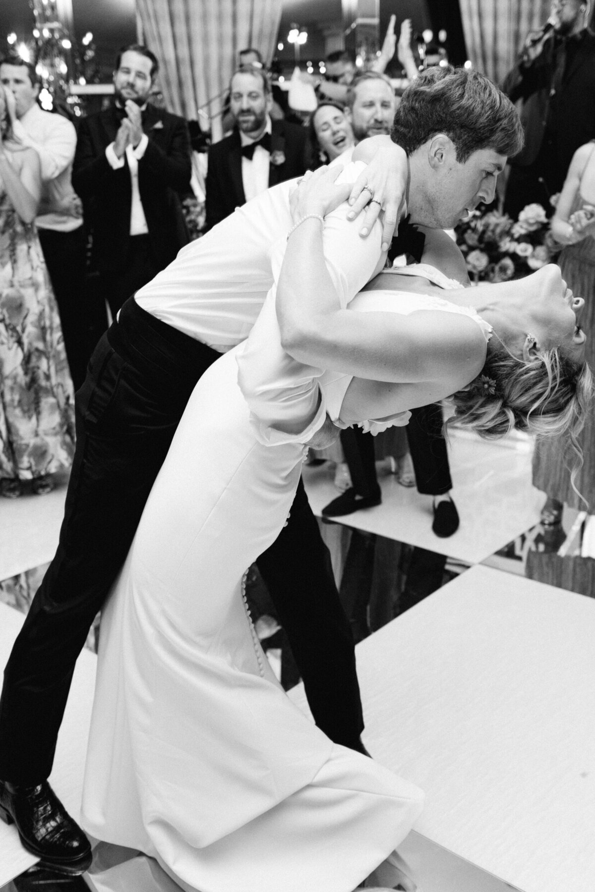 A black and white wedding photo of the bride and groom dancing during their wedding reception.