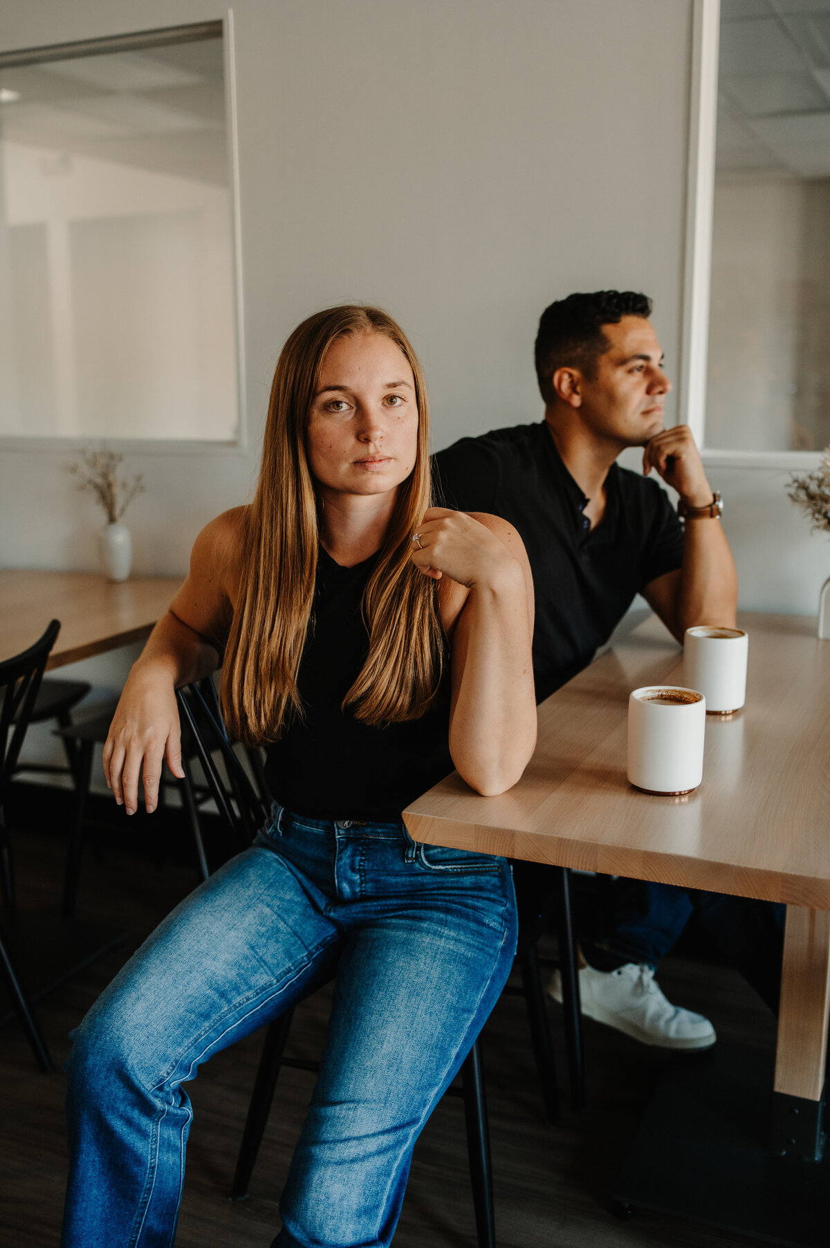couple sits and stares opposite directions at restaurant table at the yogalab in bloomington illinois.