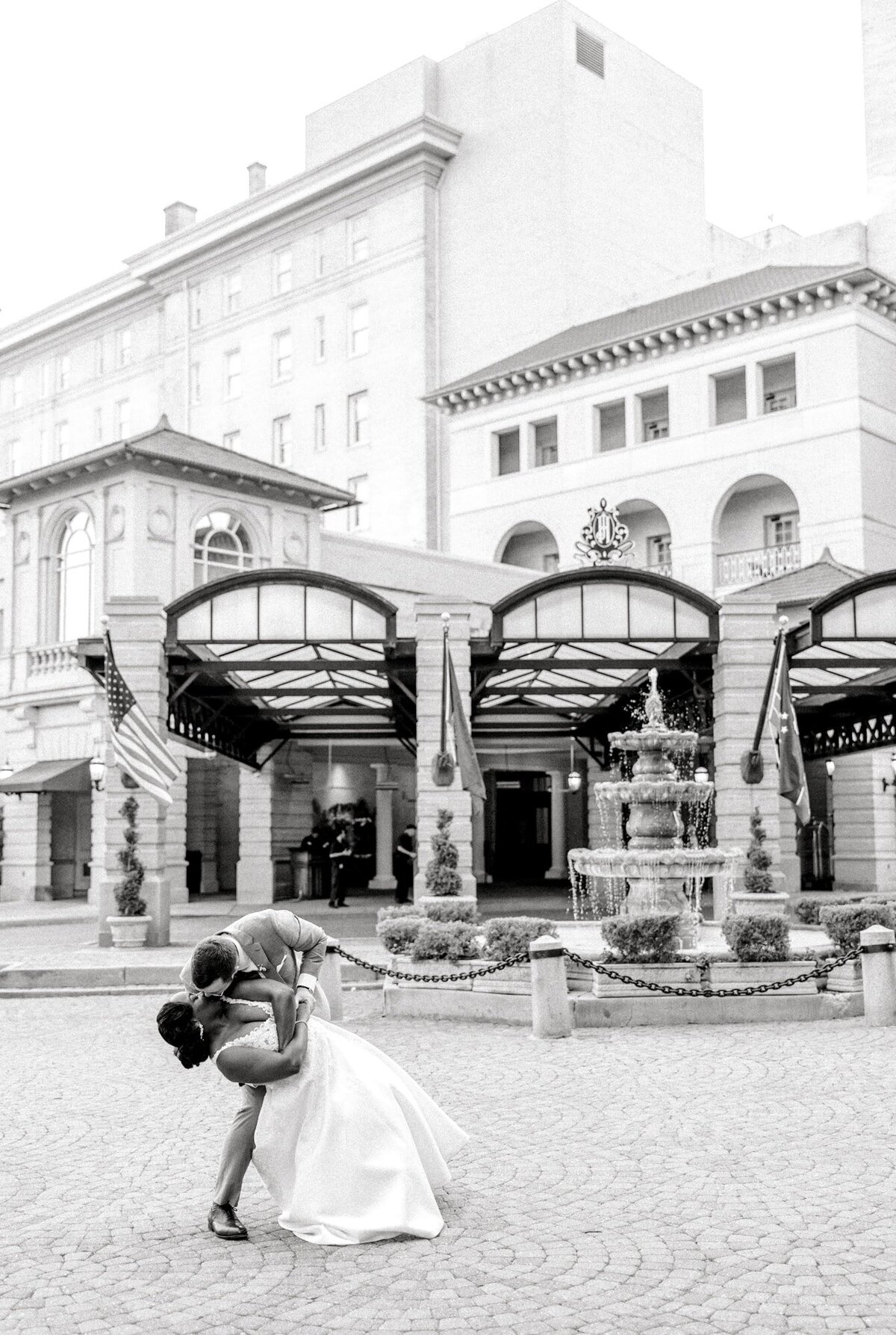 Groom dips bride in front of Jefferson Hotel Richmond on wedding day