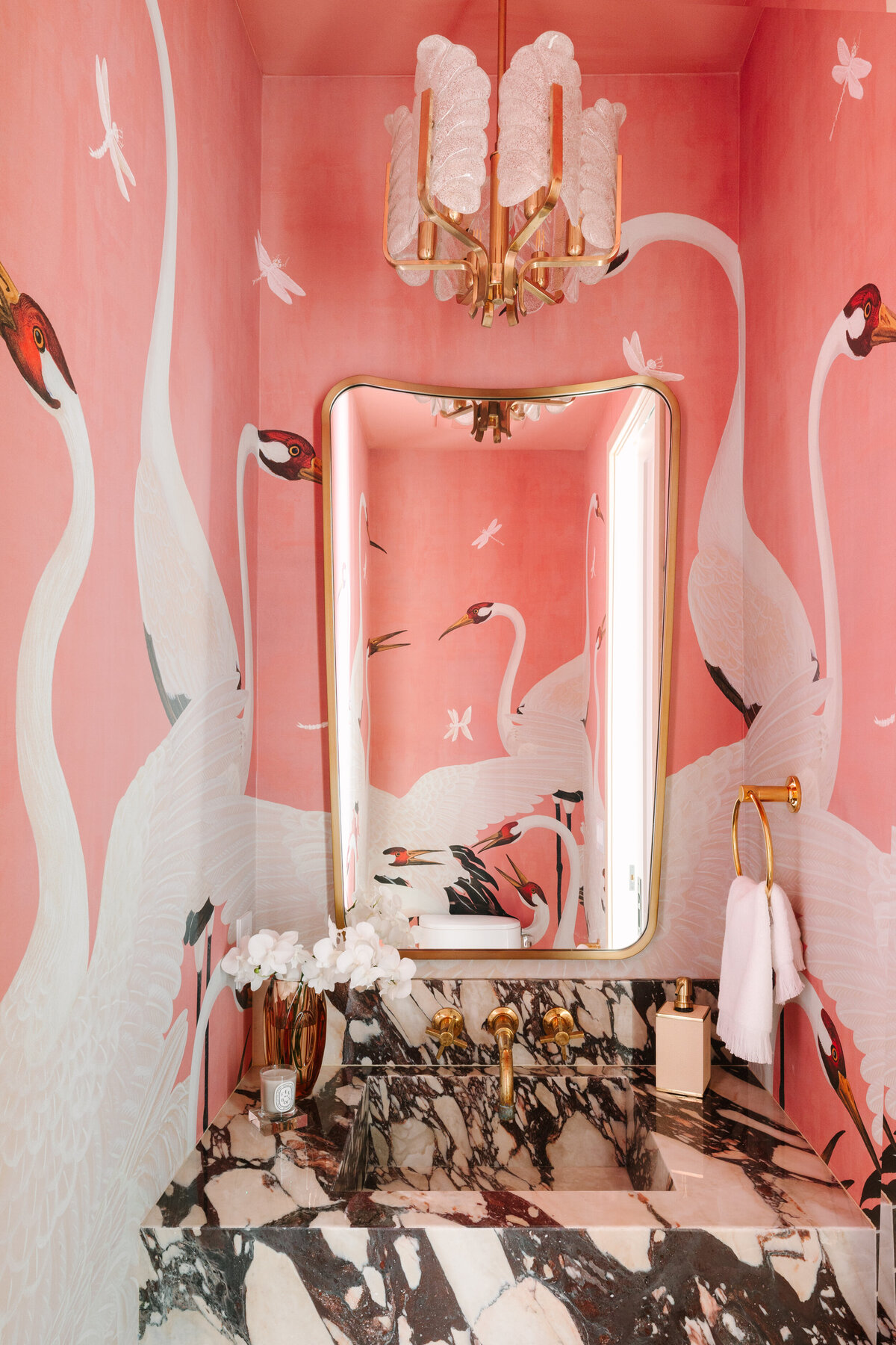 Small space powder room with Calacatta Vagli vanity and sink, Gucci Heron wallpaper, Italian shield mirror, and vintage Carl Fagerlund for Orrefors 1960's pendant.