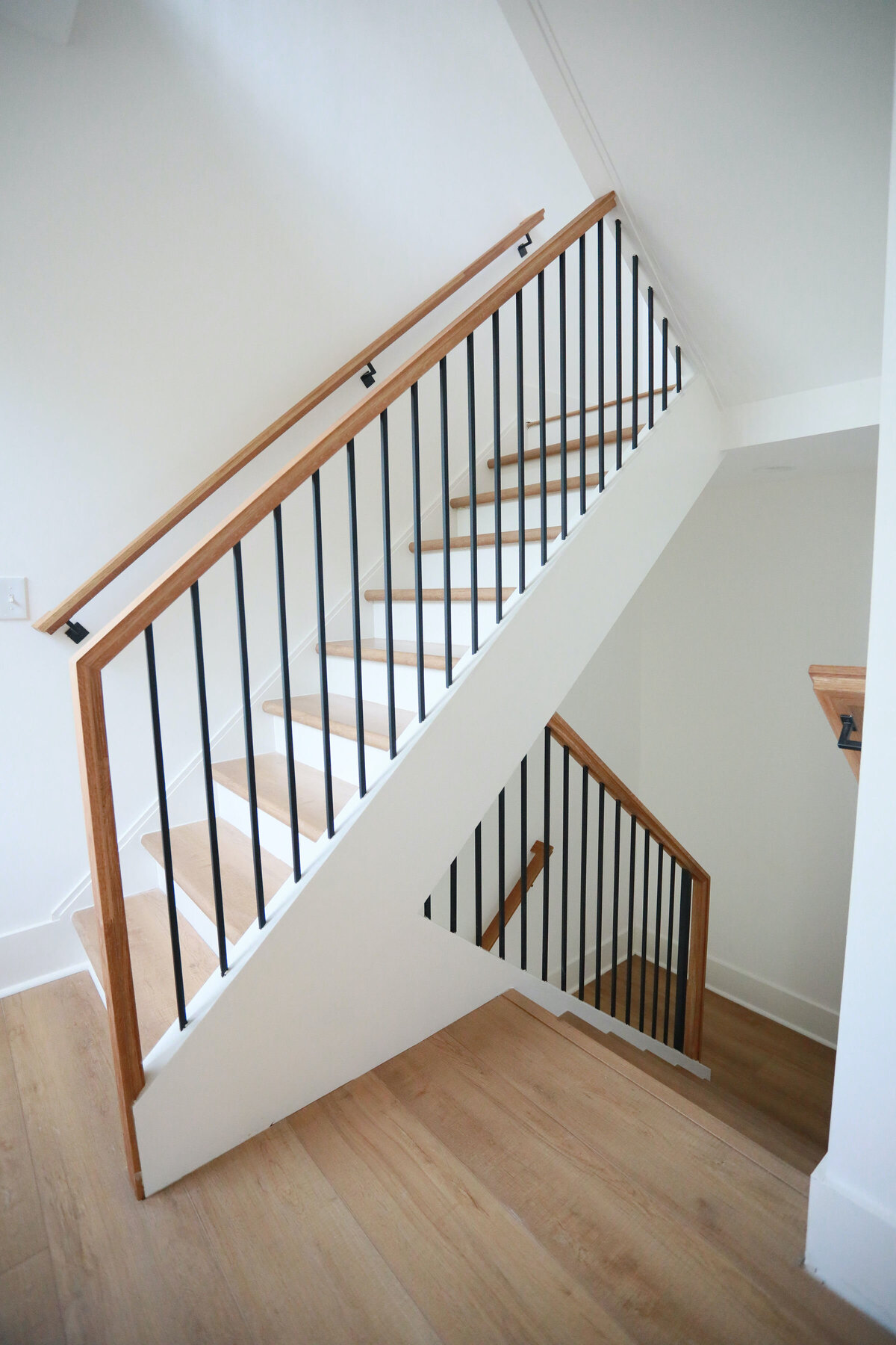 modern stairs with black and light wood railings