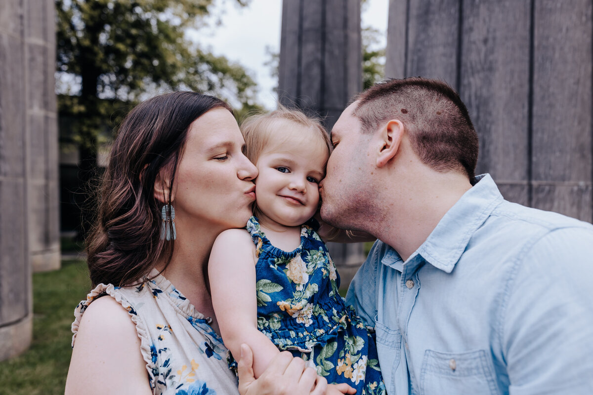 Nashville family photographers capture parents kiss child's cheeks