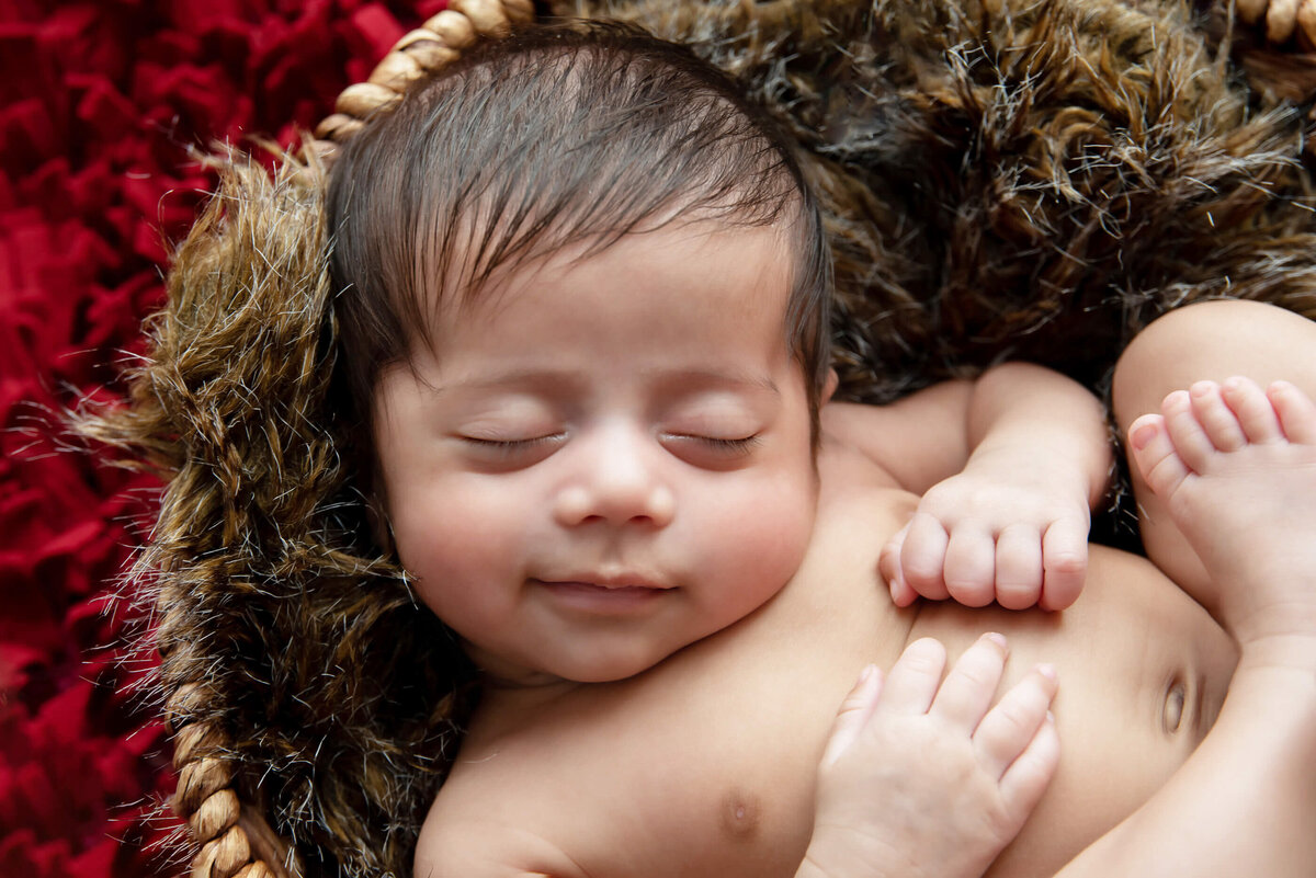 up close photo of a newborn boy with brown hair for his newborn photography session