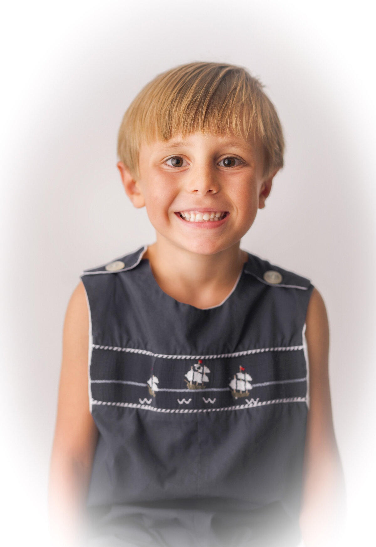 Little boy smiles at the camera during Heirloom Photoshoot in Charleston.